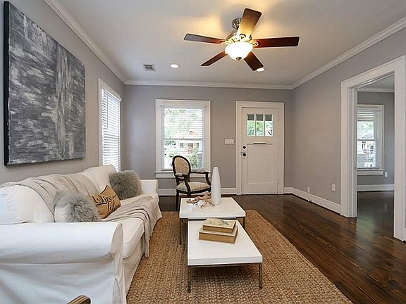 This spacious living room features high ceilings and crown molding. Large windows and recessed light