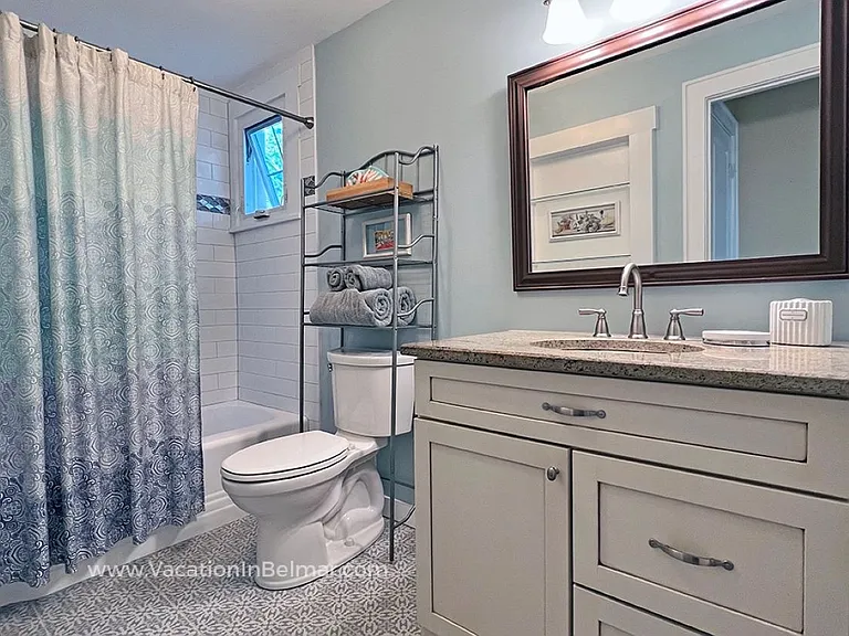 Immaculate, updated bathroom with granite, full tub, and custom-tile shower.