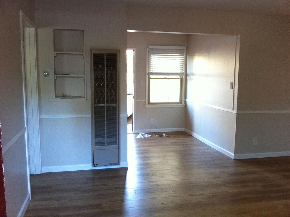Living room facing eat-in kitchen with back door leading to parking lot