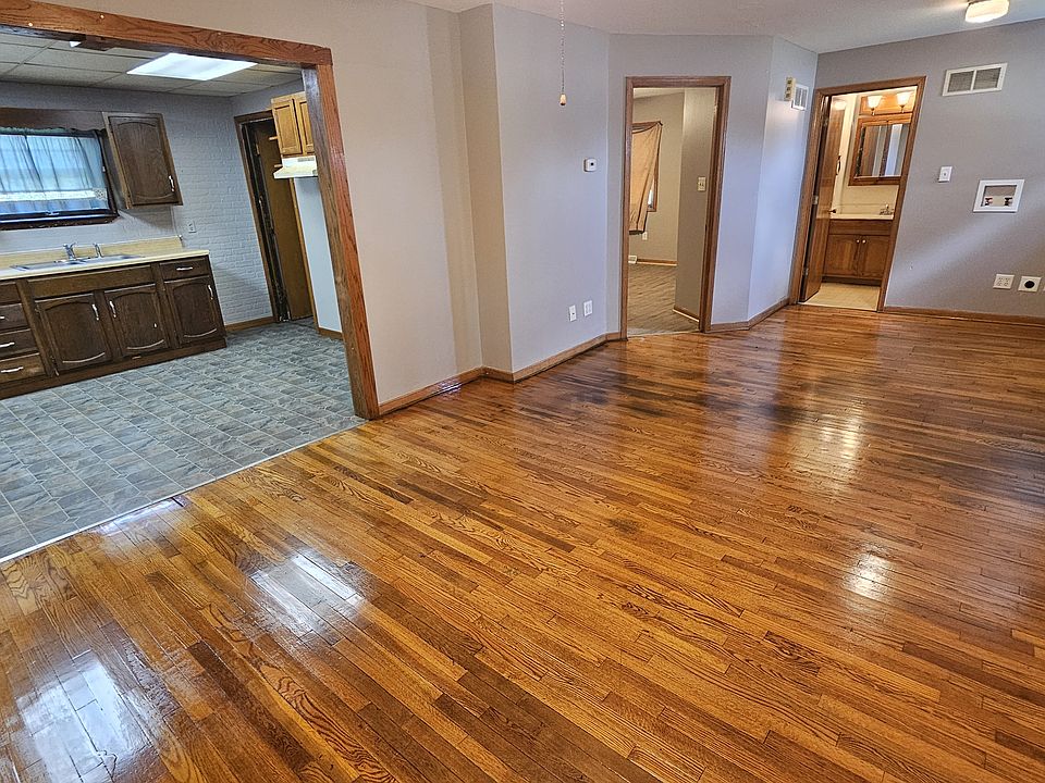 Living room, front door on righthand wall, bedroom and bathroom doors on far wall, kitchen on left.