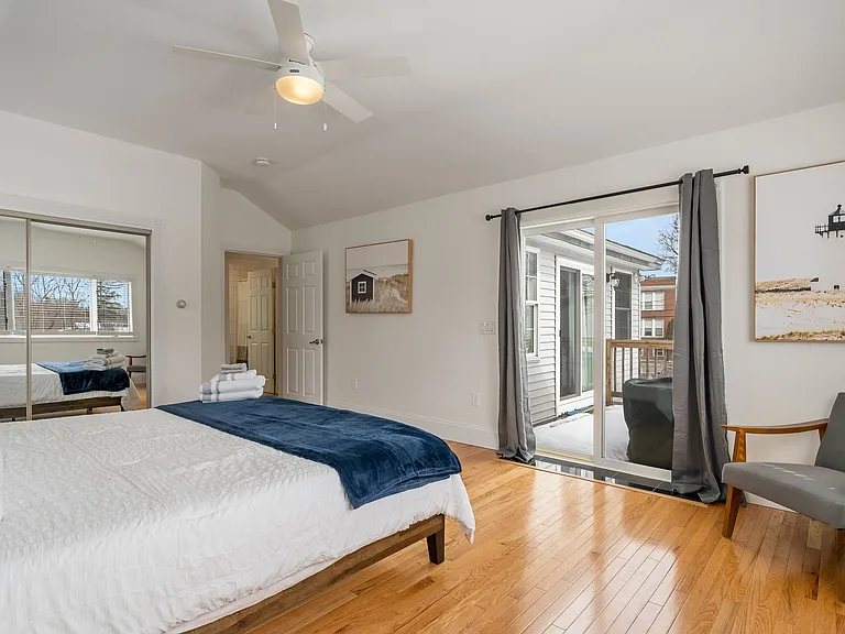 Master Bedroom, Hardwood Floors, Sliding Glass Door, Balcony Access, Ceiling Fan, Mirrored Closet, Natural Light.