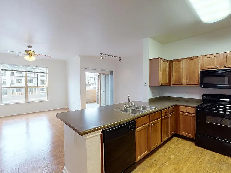 Apartment kitchen with wood-style flooring.