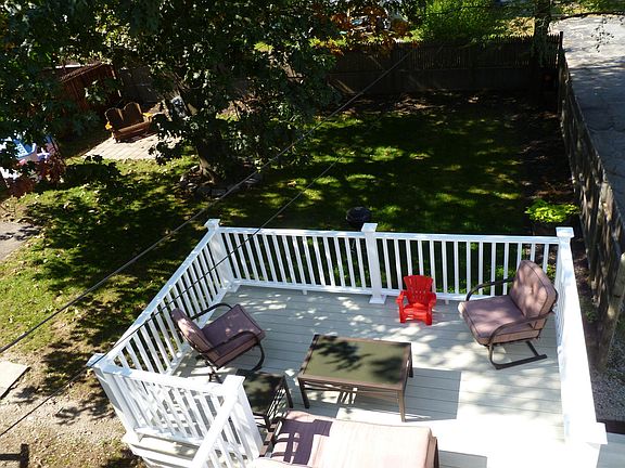 Spacious deck overlooking fenced-in back yard.
