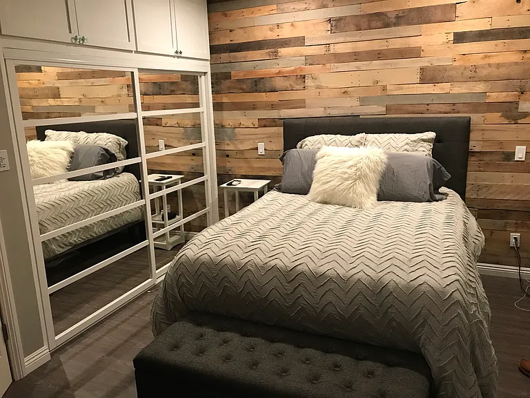 Main bedroom with mirrored closet doors and storage