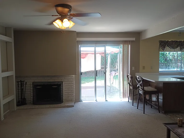 Family Room off kitchen with fireplace and ceiling fan