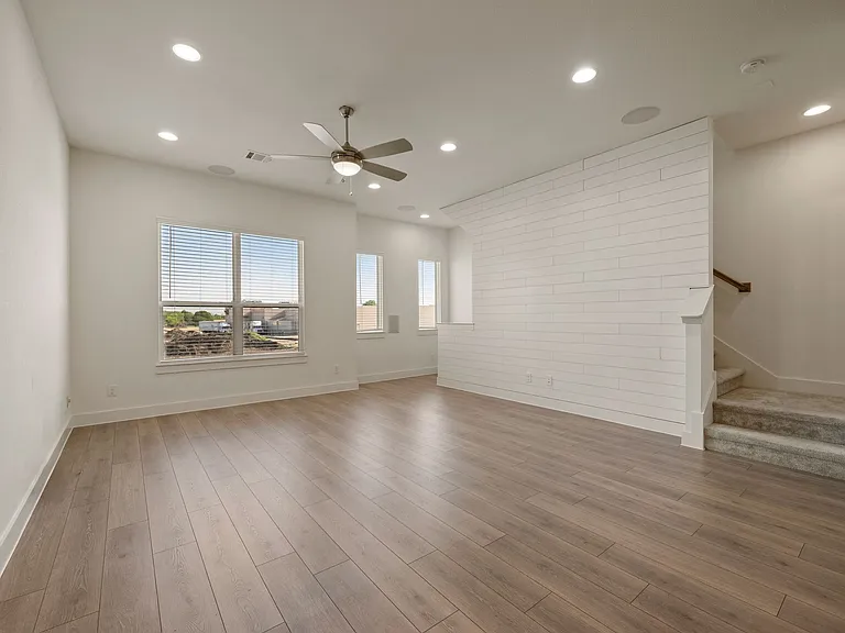 Living room with ceiling fan, gorgeous recessed lighting and multiple windows for great views and lots of natural light!