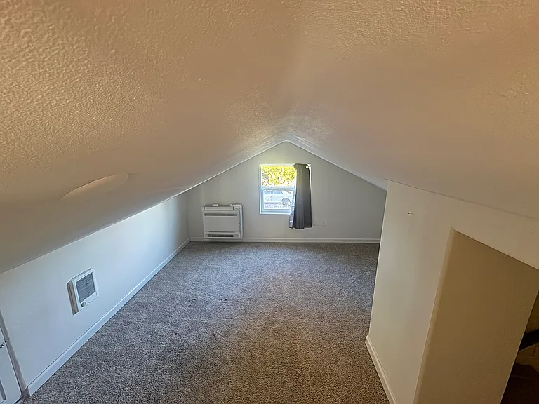 Upstairs bedroom with heat/AC unit and closet