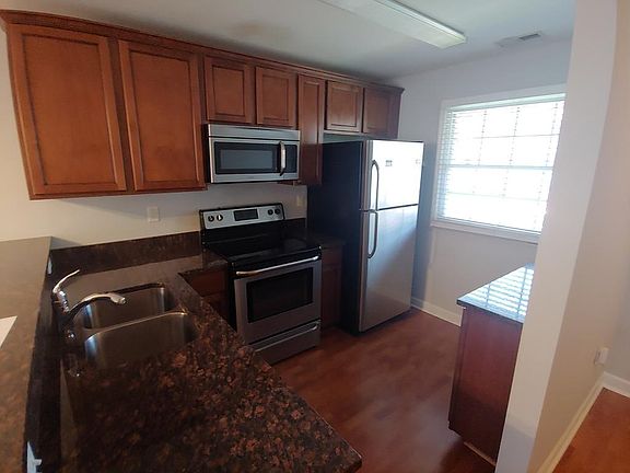 Kitchen furnished with fridge, stove, oven, microwave, dishwasher, and disposal.