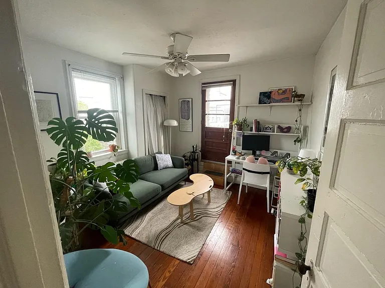 Photo from 2024 showing back room being used as a living room/office . In 2021 this was being used as a bedroom. Notice the door to the deck.