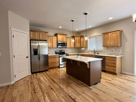 Large kitchen with stainless steel appliances, great storage, and dining area.