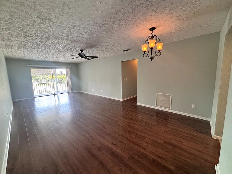 From front door looking into living room/dining area. Kitchen is on the other side of the right wall. Hallway to bedrooms in middle.