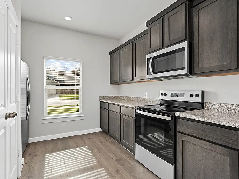 The kitchen has beautiful wood cabinetry.