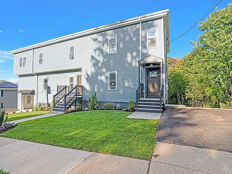 Front Door with driveway on the right. Stairs going down to the back yard.