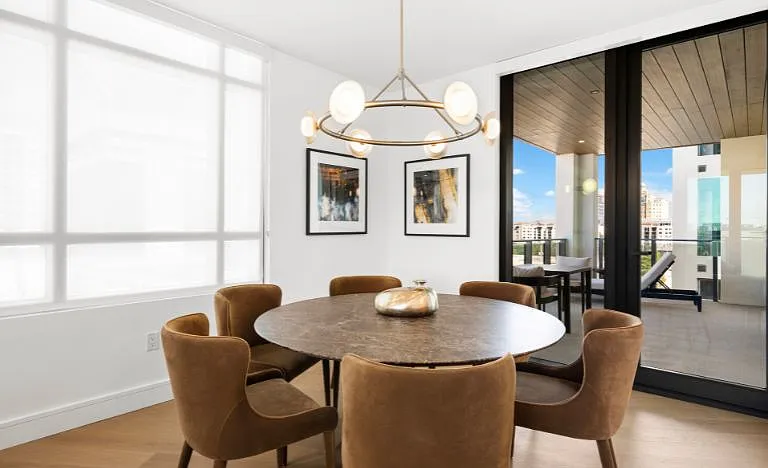 Dining area with Restoration Hardware furnishings, offering an elegant setting and balcony views.