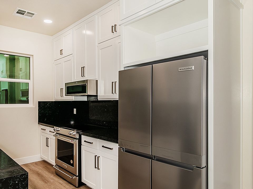 High End KitchenAid Appliances, Custom Cabinets to the Tall Ceiling & High End Quartz Counters in Galley Kitchen.