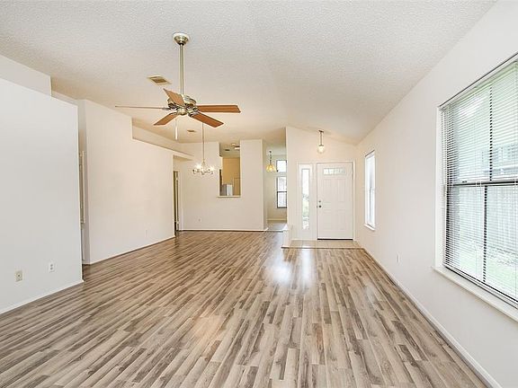 The laminate flooring flows throughout the home, from the living and dining area, into the primary suite and both of the secondary bedrooms.