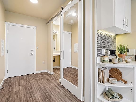 A mirrored sliding door and a corner coffee station make good use of a compact entry.
