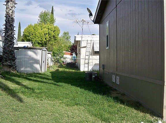 Back yard with shed and view of A/C unit