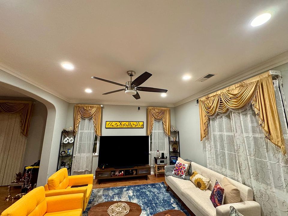 Spacious living room with attached dinning area with traditional look curtains