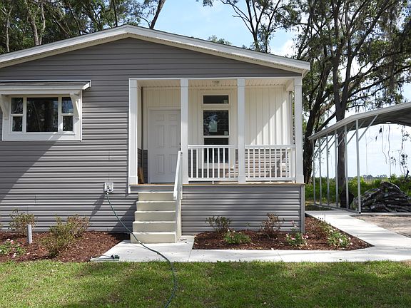 Additional view of the front of the house including the sidewalk to the covered carport area.