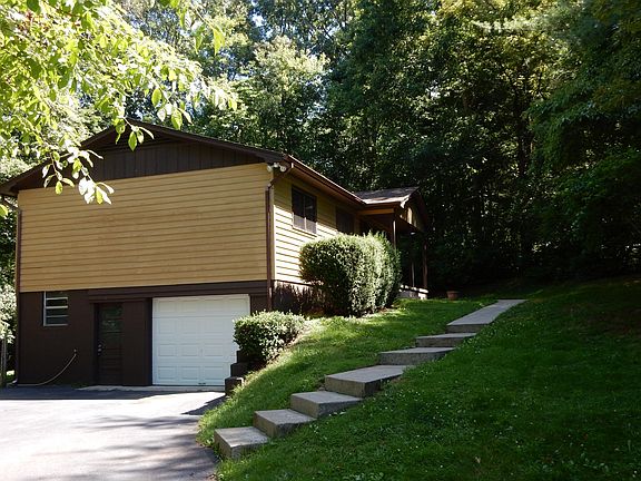 Front and side view of home with garage under, from driveway.