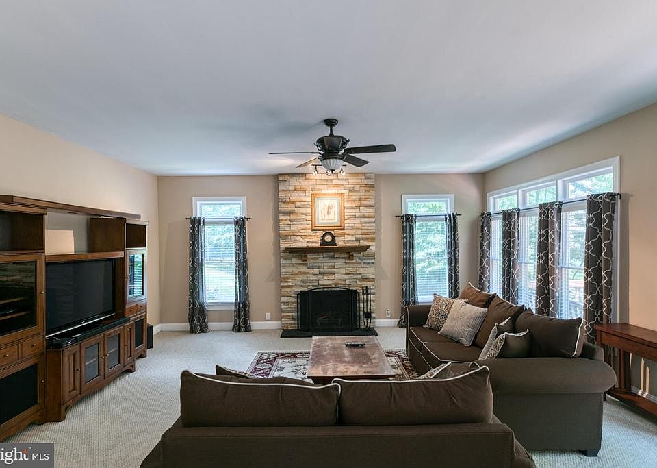 Family room with stone, wood burning fireplace.