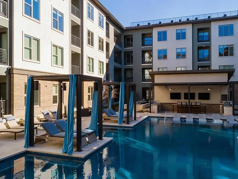 Poolside View of Clubhouse with Cabanas and Lounge Seating