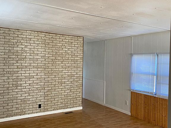 Living room is spacious has laminate flooring.