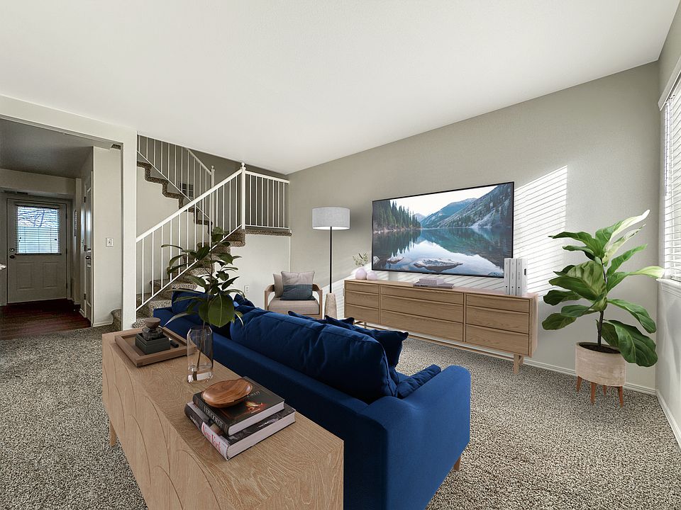 Liberty Hill Apartments, Draper, Utah, living room with a blue couch, a wooden coffee table, a staircase, and a large painting on the wall.