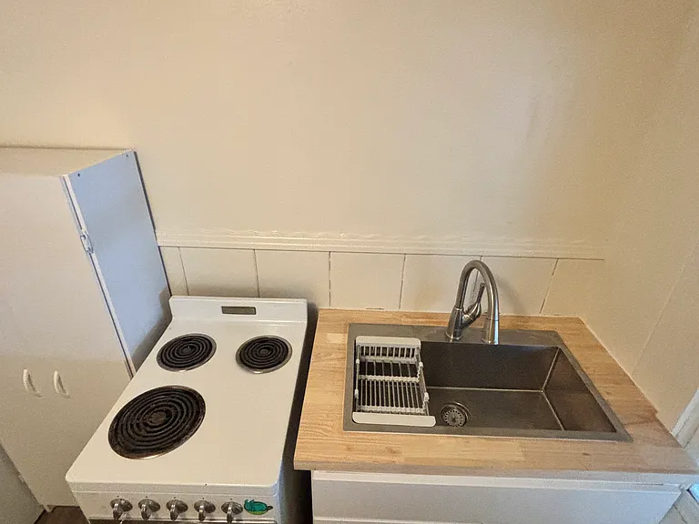 A brand new kitchen sink, cabinets and pantry.