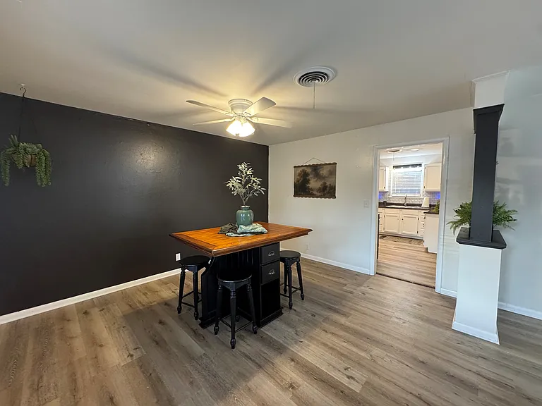 Pub table w/ stools is near kitchen.