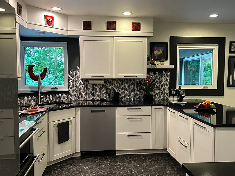kitchen with windows overlooking patio and wooded slope down to the creek