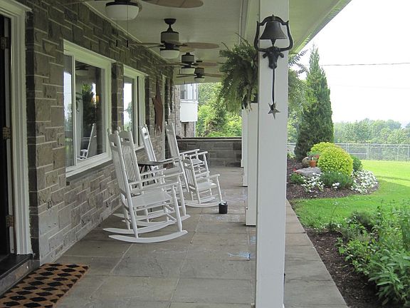 Front porch with outdoor fans and a wainscoat cieling