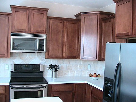 Stainless appliances, travertine backsplash, Corian countertops