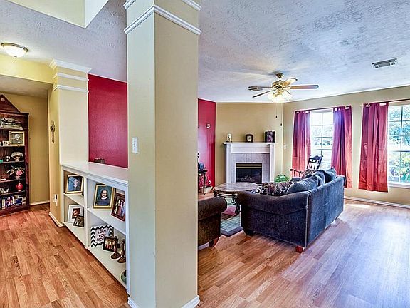 Open concept living room with bookcase divider and plenty of natural light.