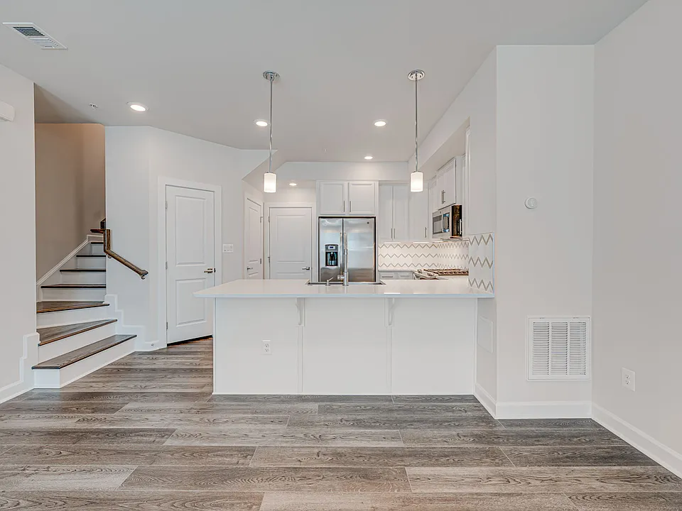 Upgraded kitchen with white quartz countertops and stainless steel appliances
