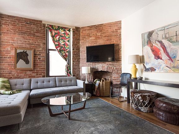 living space with non working fireplace and exposed brick
