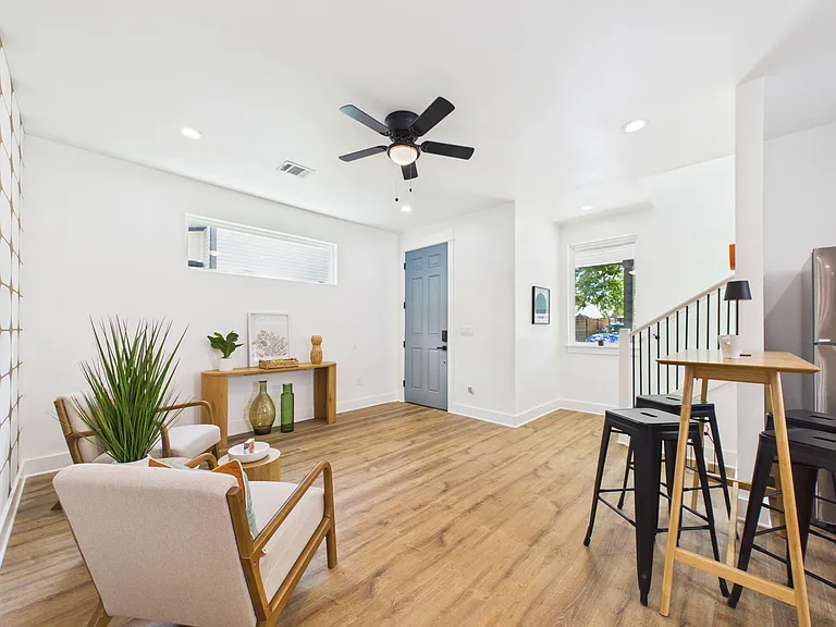 Open-concept living area with wood-style floors, recessed lighting, ceiling fan, and a convenient breakfast bar for seating.