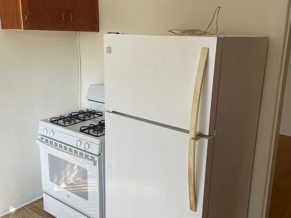 View of the kitchen with the gas range and refrigerator.