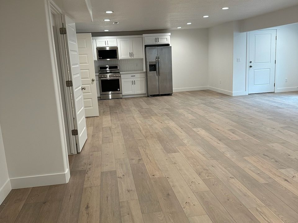 Open-concept living room with a full-size refrigerator, oven, microwave, and dishwasher.