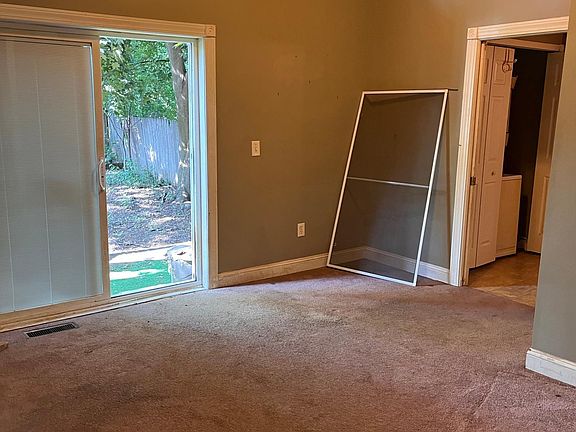 Living Room with patio doors to back deck and yard. Downstairs Bath and laundry thru doorway