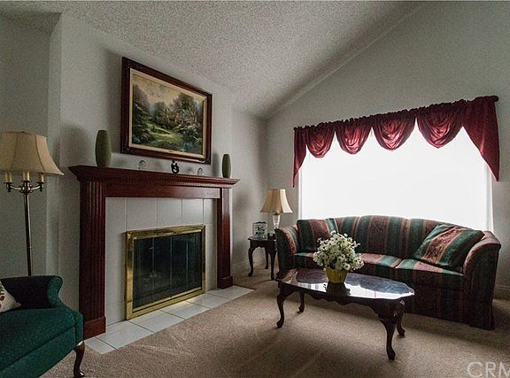Living room with cozy fireplace and vaulted ceilings