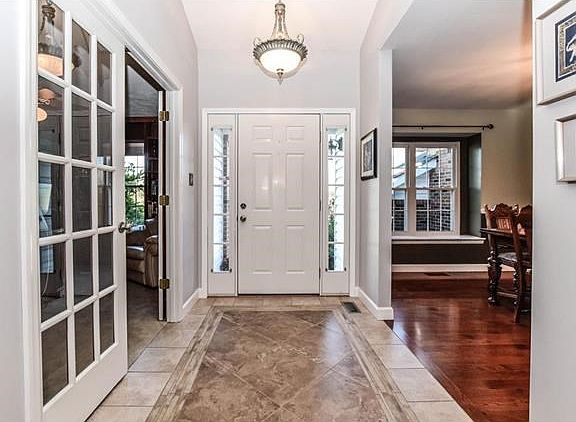 Elegant front entry with tile floors, flanked by the home office and formal dining room