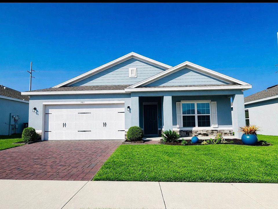 Inviting front entrance with covered porch and landscaped yard.