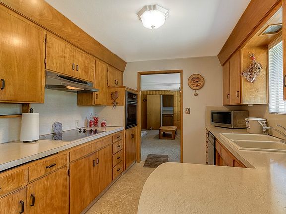 Custom Hardwood Cabinets Feature Wooden Shelves, Drawer Dividers, and Under Cabinet Lighting.  This View is from the Eating Space in Kitchen Looking toward the Gathering Room