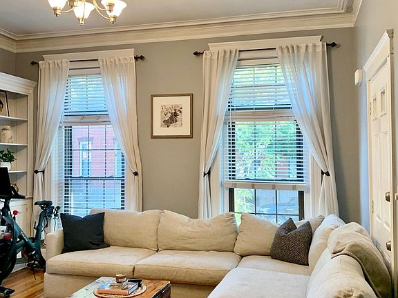 Huge bright living room with 14ft ceilings, floor to ceiling windows, and gorgeous built in shelves