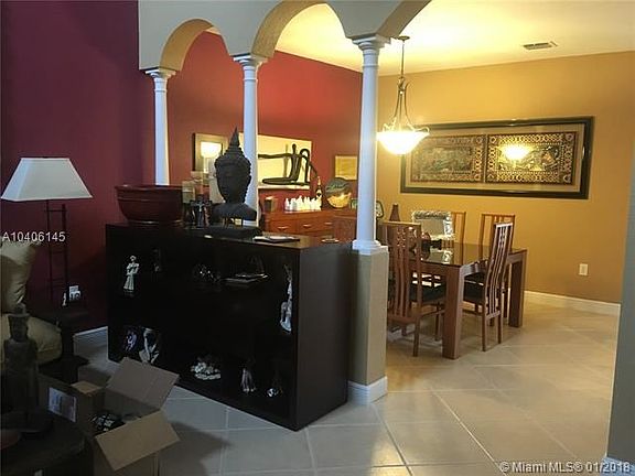 Large living room/dinning room area with high ceilings and ceramic floor.