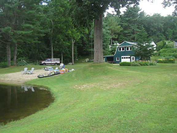 Swimming pond with beach in backyard