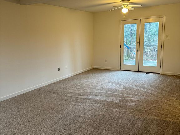 living room with ceiling fans, door to rear deck
