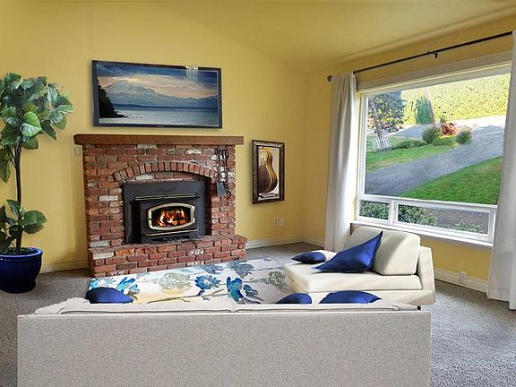 Living room with fireplace and large picture window where you will see beautiful sunsets